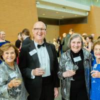 Guests in the Grand Gallery holding drinks before the Enrichment Dinner.